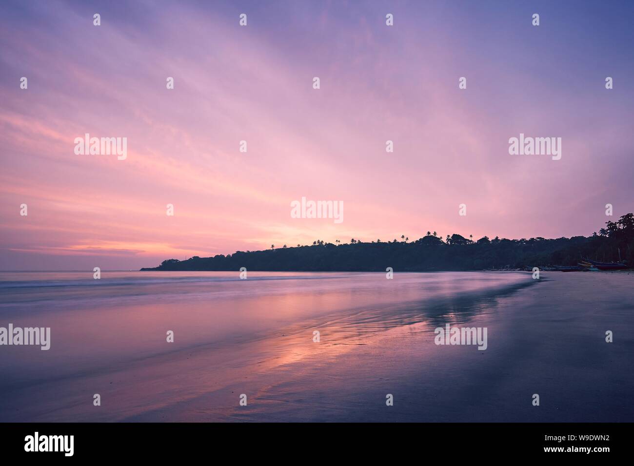 Svuotare la spiaggia della sabbia contro la costa a incredibili sunrise. Tangalle, Sri Lanka. Foto Stock
