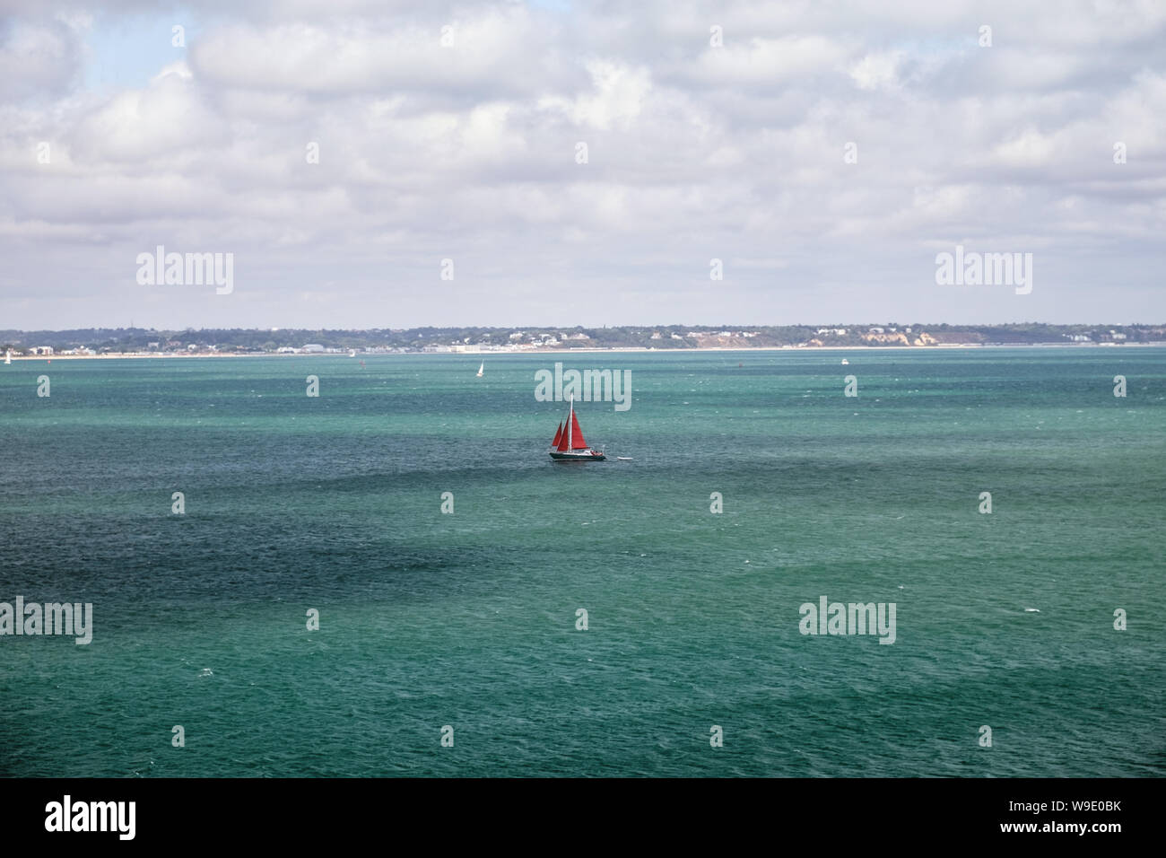 Sailing yacht con il red sail va sul mare turchese, canale inglese, Regno Unito Foto Stock
