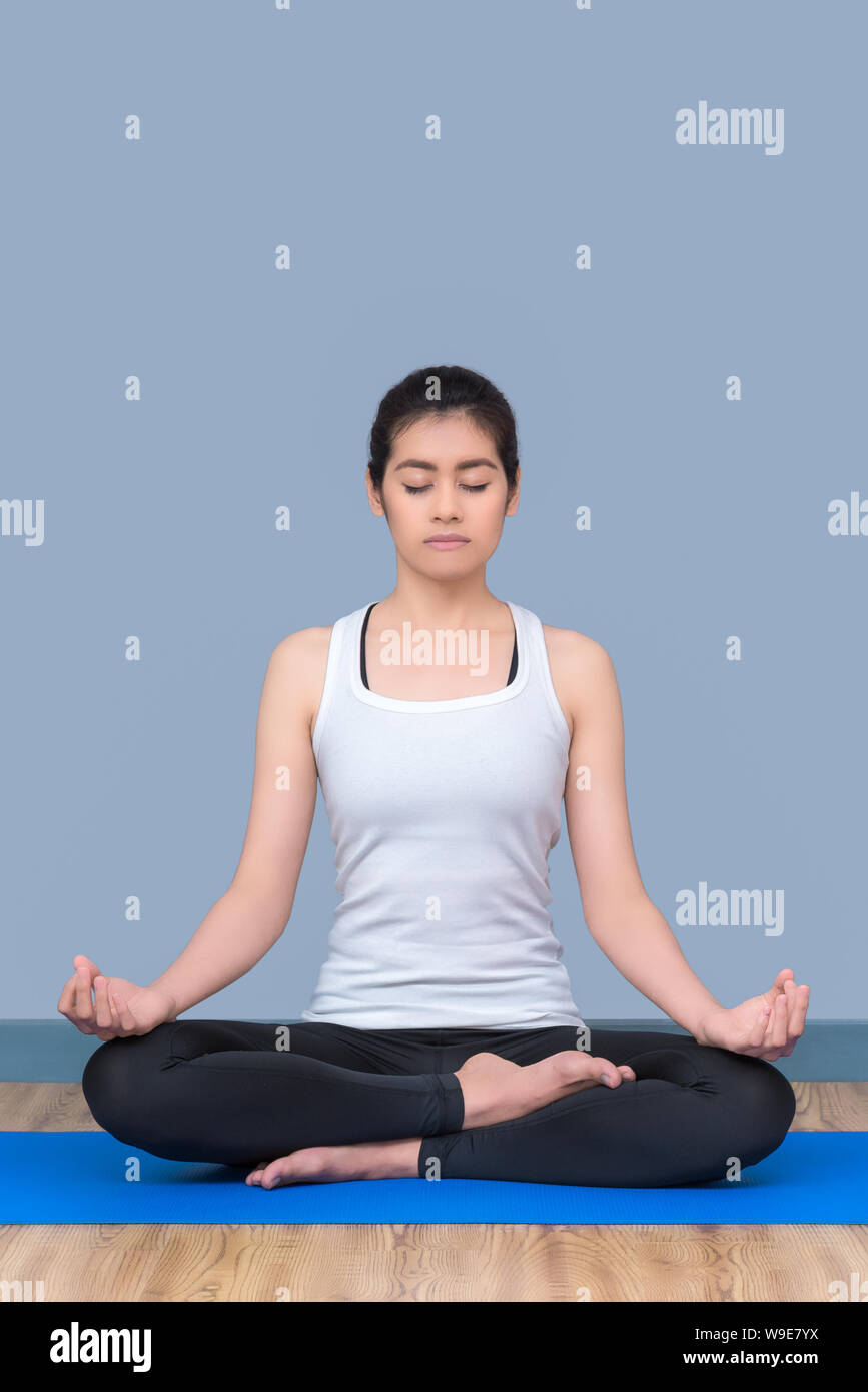 Donna asiatica di mantenere la calma e la medita durante la pratica dello yoga per esplorare la pace interiore. Lo yoga e la meditazione hanno buone prestazioni per la salute. Foto Stock