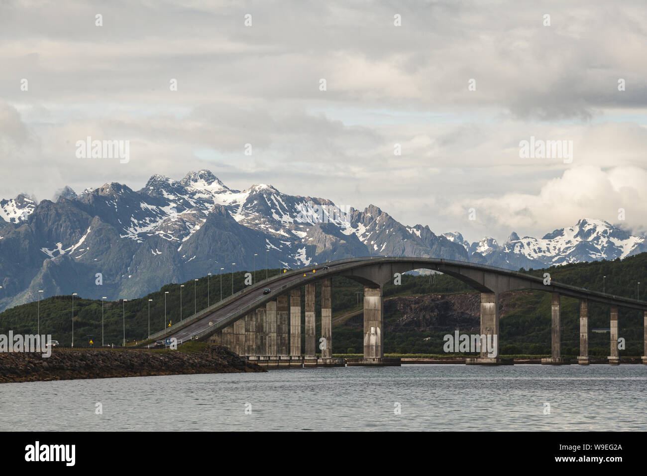 Il Hadsel Bridge da Stokmarknes a Langøya con una vista delle montagne di Lofoten Foto Stock