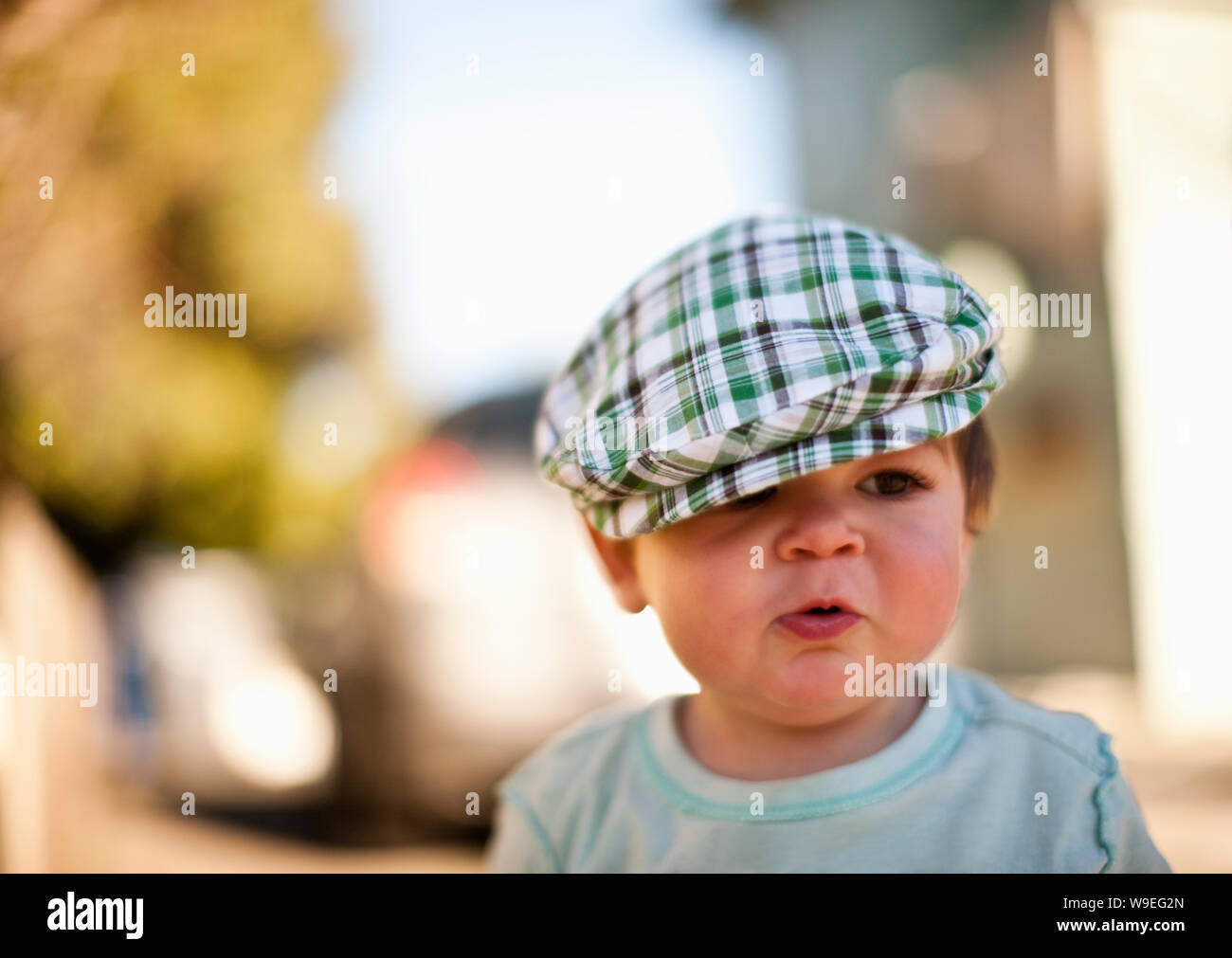 Il Toddler boy in piedi indossando un formaggio-cutter hat. Foto Stock