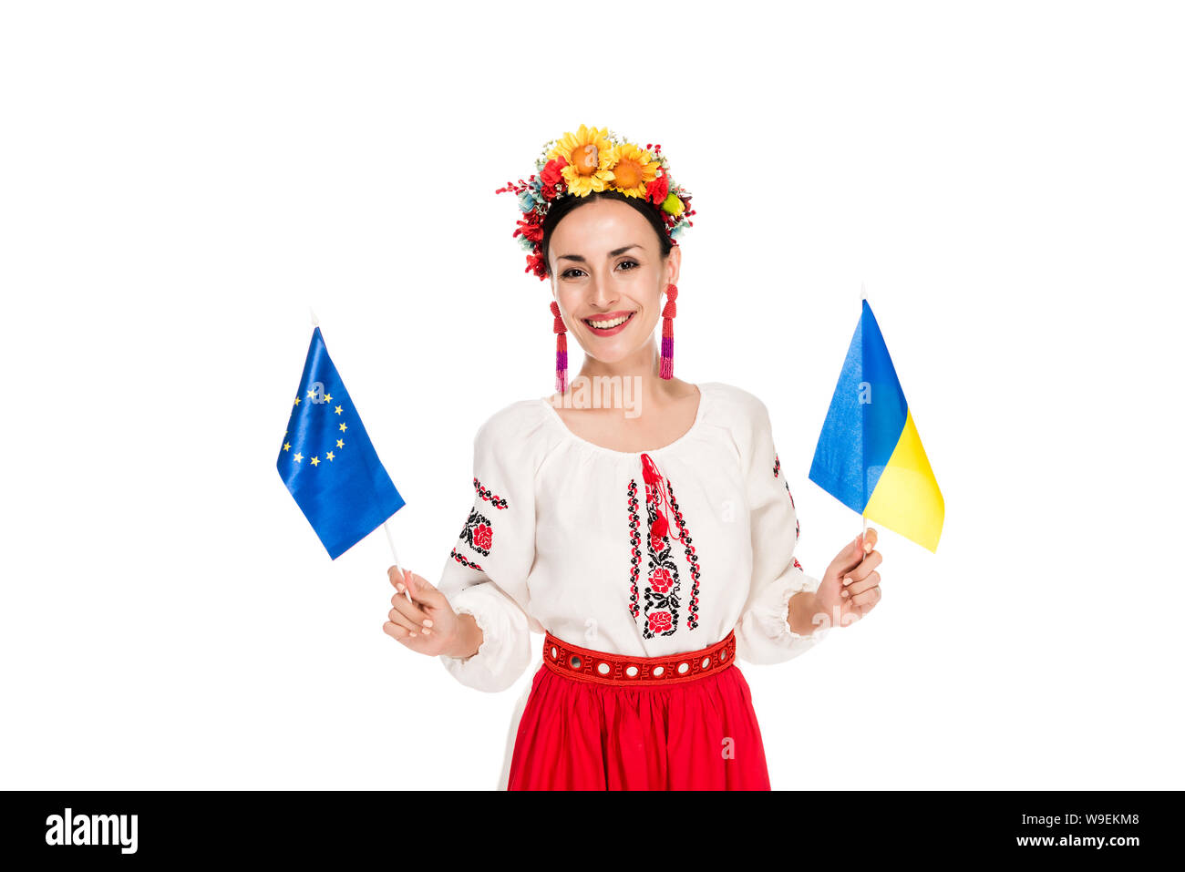 Felice bruna giovane donna in nazionale ucraino azienda costume europeo e bandiere ucraine isolato su bianco Foto Stock
