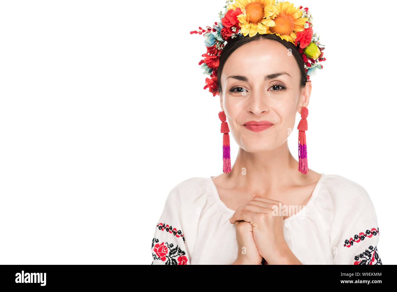 Felice bruna giovane donna in nazionale ucraino camicia ricamata e ghirlanda floreale isolato su bianco Foto Stock