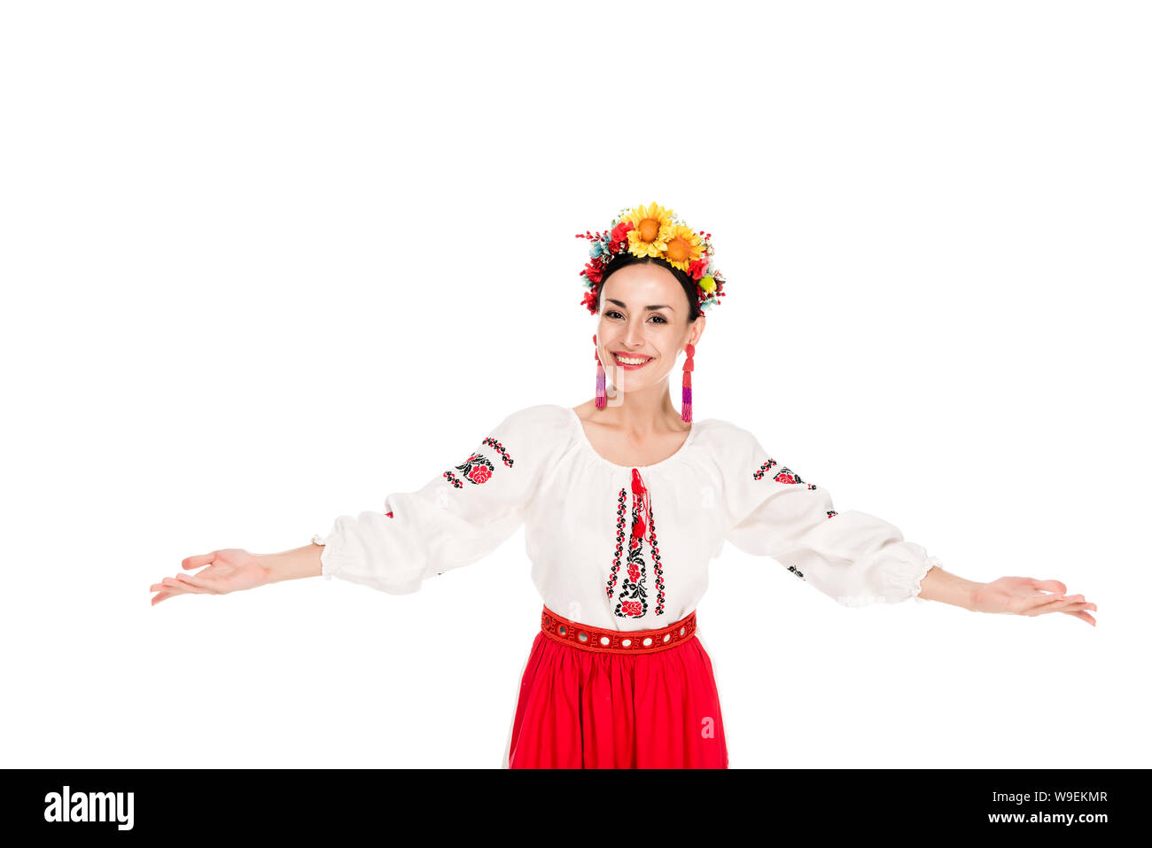 Felice bruna giovane donna in nazionale costume ucraino facendo gesto di benvenuto isolato su bianco Foto Stock
