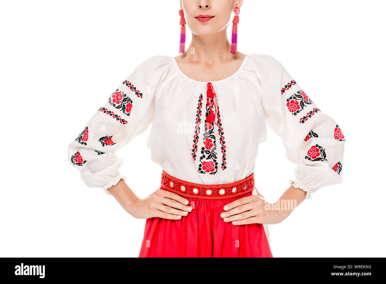 Vista ritagliata della giovane donna in nazionale costume ucraino in piedi con le mani sui fianchi isolato su bianco Foto Stock