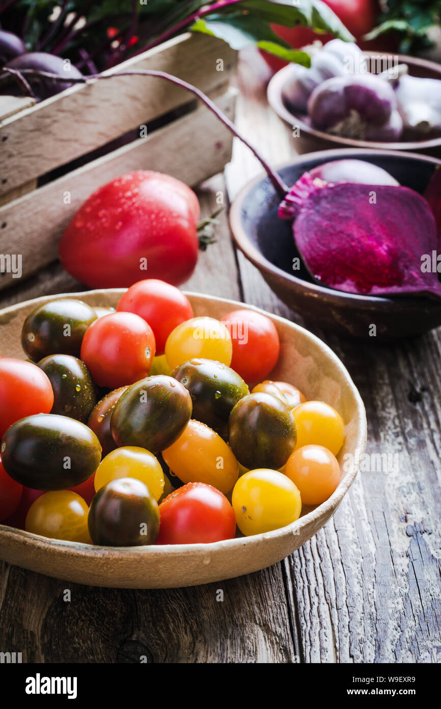 Fresco colorato Organici ortaggi su tavola in legno rustico, mangiare sano, impianti alimentari a base di ingredienti di cottura, barbabietole, pomodori, fagioli, gar Foto Stock