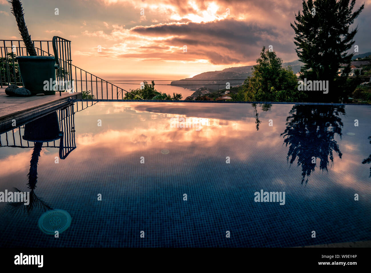 Tramonto acqua riflessioni a piscina infinity, moody di toni Foto Stock