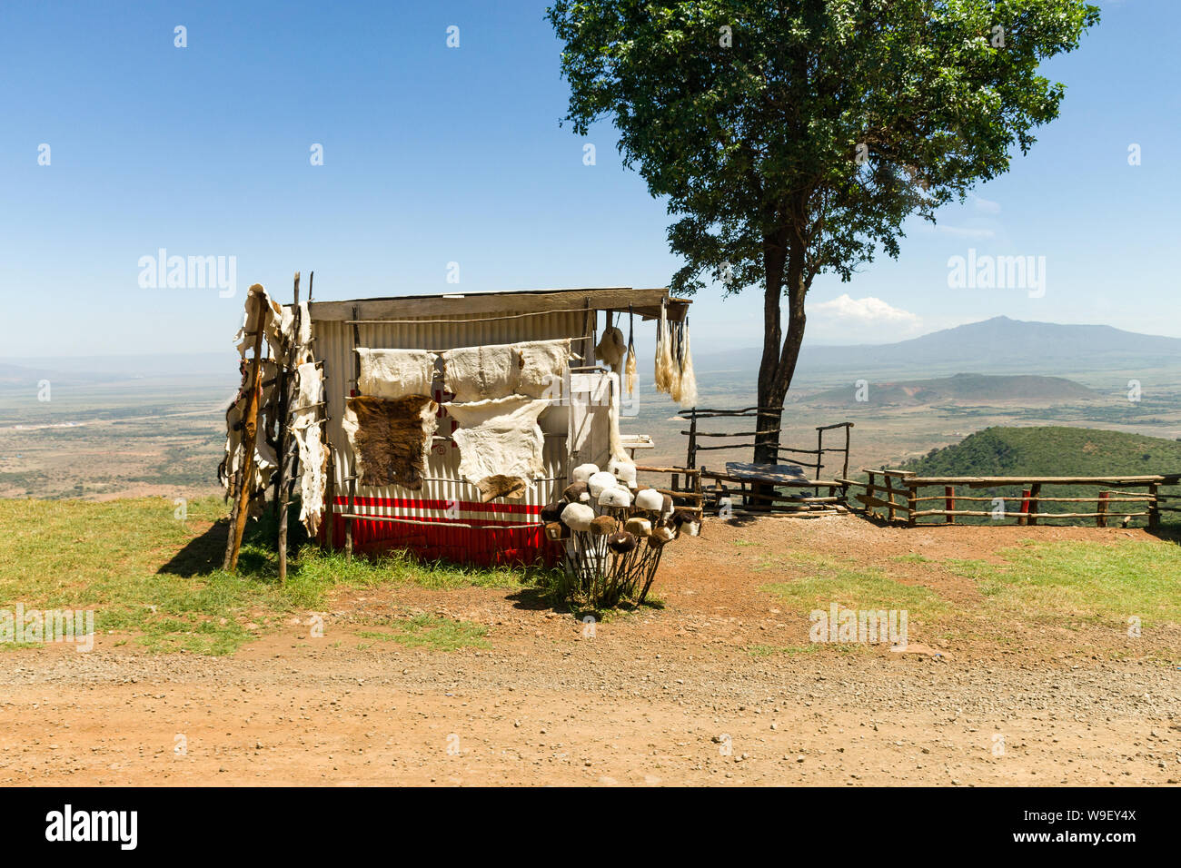 Una piccola curiosità shack bancarella vendendo tappeti di pelle di pecora e cappelli con Rift valley in background, Kenya Foto Stock
