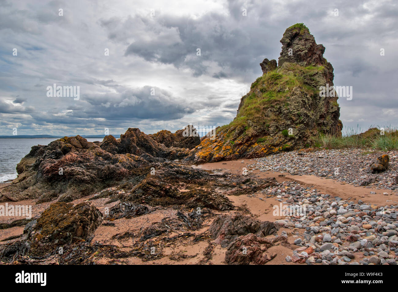 ROSEMARKIE Black Isle Ross and Cromarty Scozia Rocks Beach e ricoperto di erba mare pila lungo il sentiero grotta IN ESTATE Foto Stock