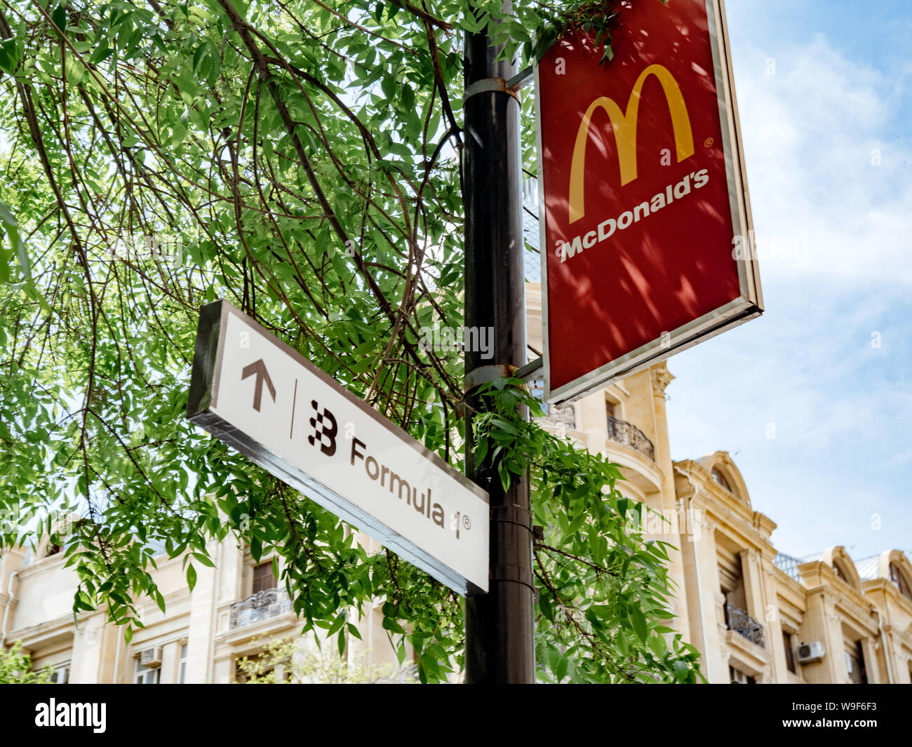 Baku in Azerbaijan - 2 Maggio 2019: McDonald's e Formula 1 sign sulla stessa strada pole con architettura azero in background Foto Stock