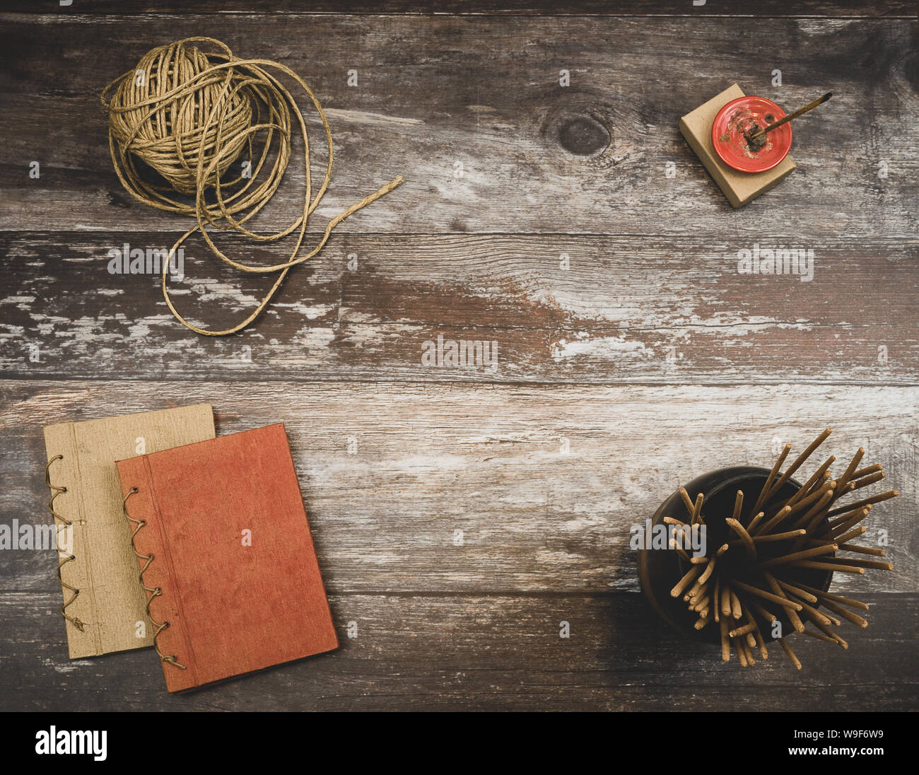 Rustico vintage vecchio tavolo di legno con brucia incenso, bastoncini di incenso, spago naturale e due piccoli libri fatti a mano, con sfondo copyspace Foto Stock