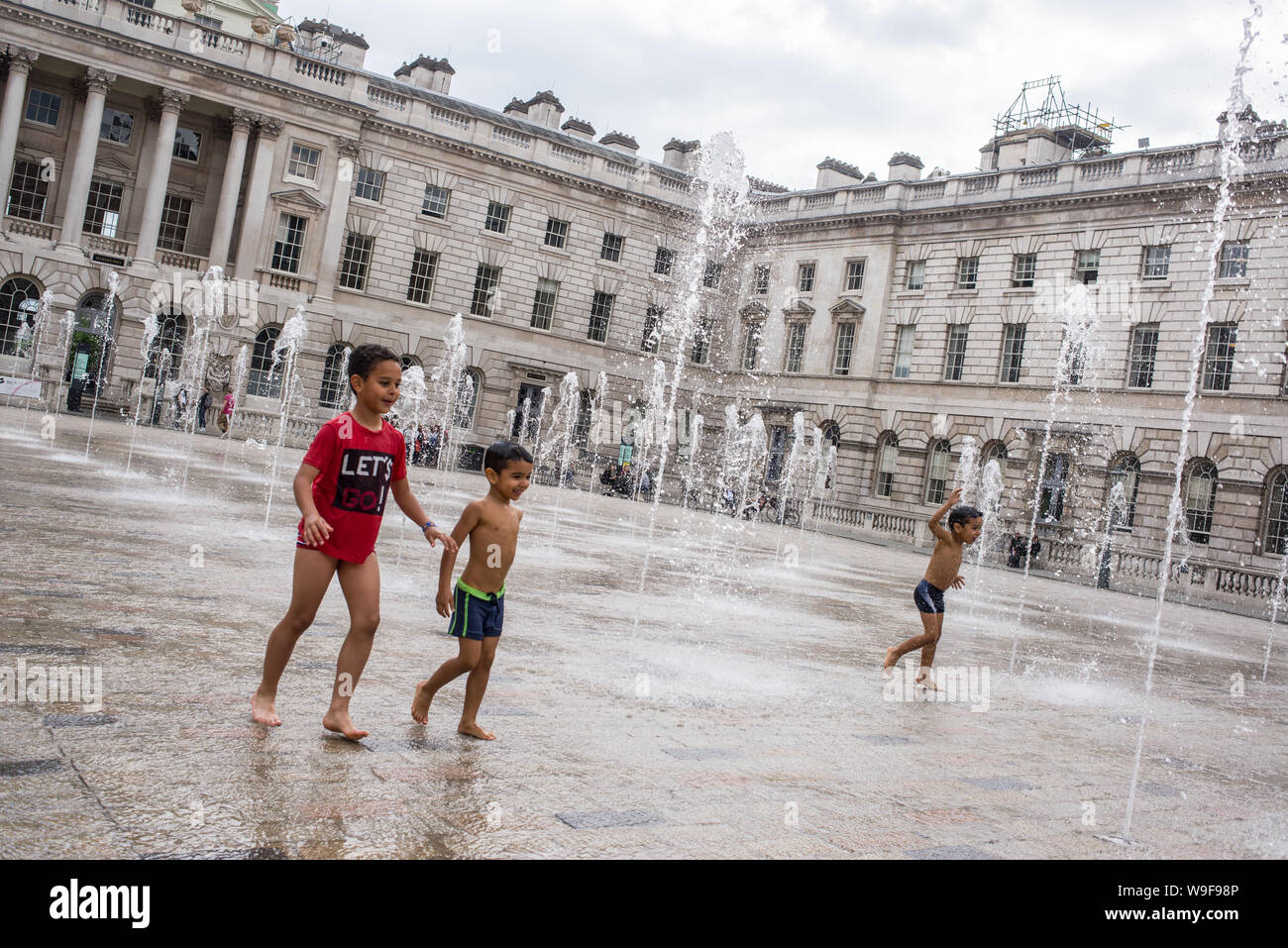 Londra, Inghilterra - Maggio 2019: bambini che giocano con le fontane di acqua nel cortile del Somerset House, London REGNO UNITO Foto Stock