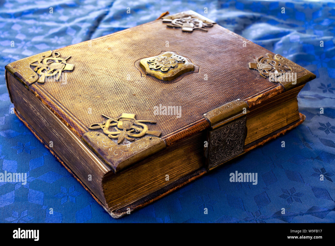 Decorate splendidamente vecchio libro oro marrone con serratura su sfondo blu Foto Stock