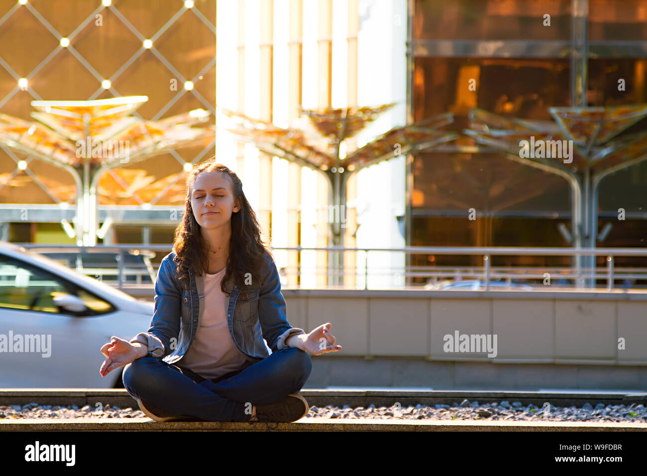 Young Teen girl le pratiche yoga e medita nella posizione del loto in una grande città Foto Stock