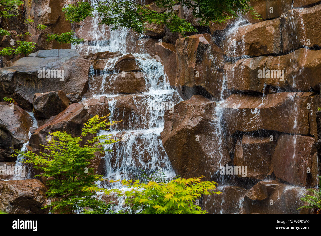 Giardino interno cascata di oltre le pietre di colore marrone Foto Stock