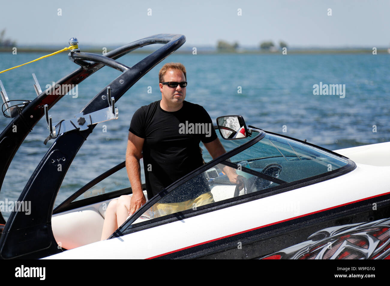 Uomo alla guida di una barca di sci mentre in piedi. Foto Stock