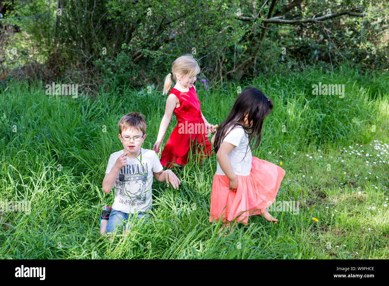 Hororata, Canterbury, Nuova Zelanda, 02 Ottobre 2016: i bambini giocano nell'erba lunga in una calda giornata estiva Foto Stock