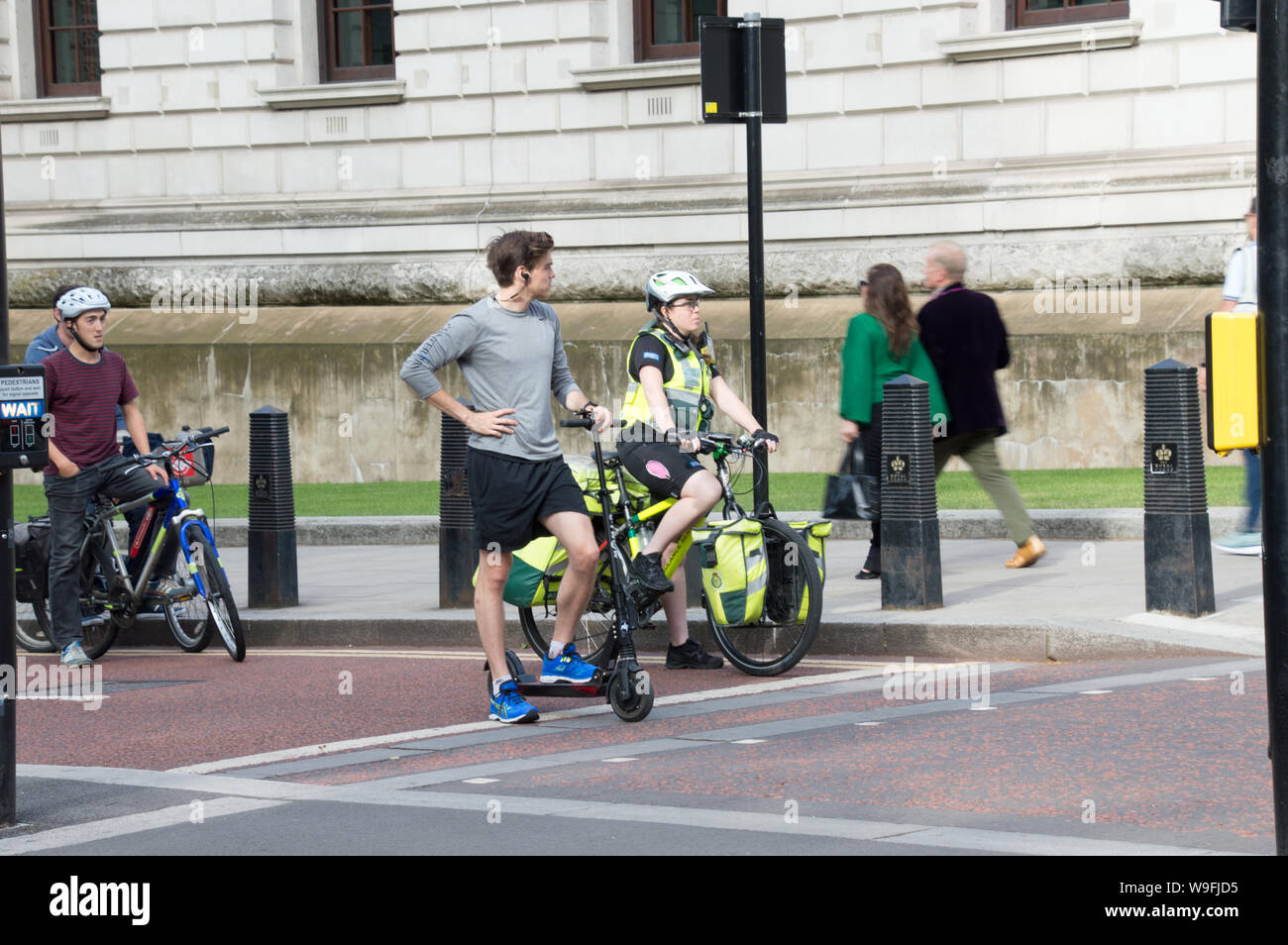 Donna paramedico in bicicletta a Londra in attesa del segnale per il segnale verde per attivare Foto Stock