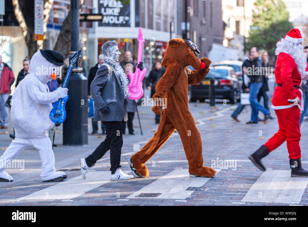 Gli uomini in abiti a fantasia attraversando le strisce pedonali, imitando Beatles, in London, England, Regno Unito Foto Stock