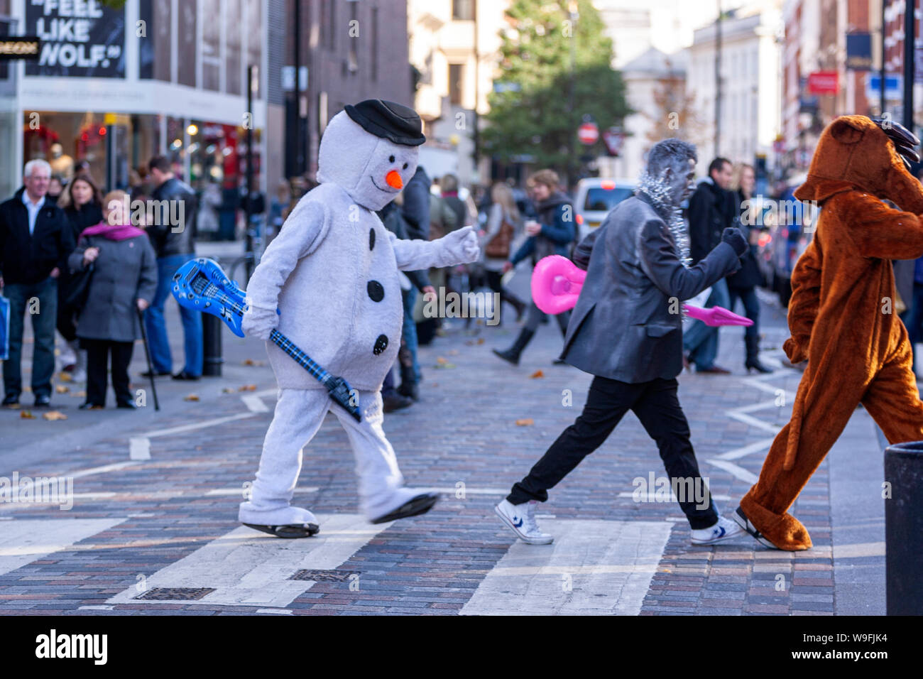 Gli uomini in abiti a fantasia attraversando le strisce pedonali, imitando Beatles, in London, England, Regno Unito Foto Stock