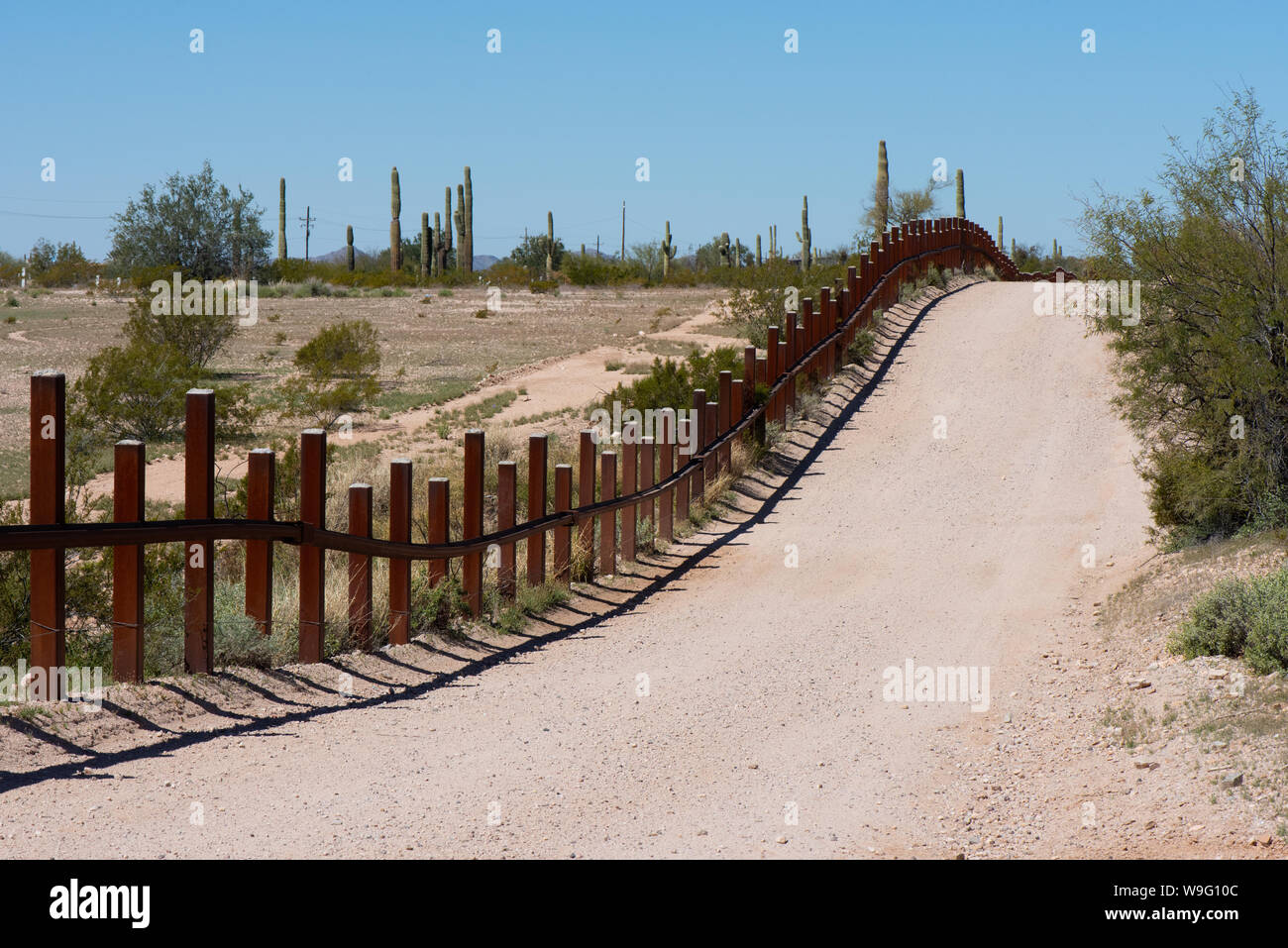 Una strada corre accanto a USA Messico frontiera in Quitobaquito molle, organo a canne Cactus monumento nazionale, Arizona Foto Stock