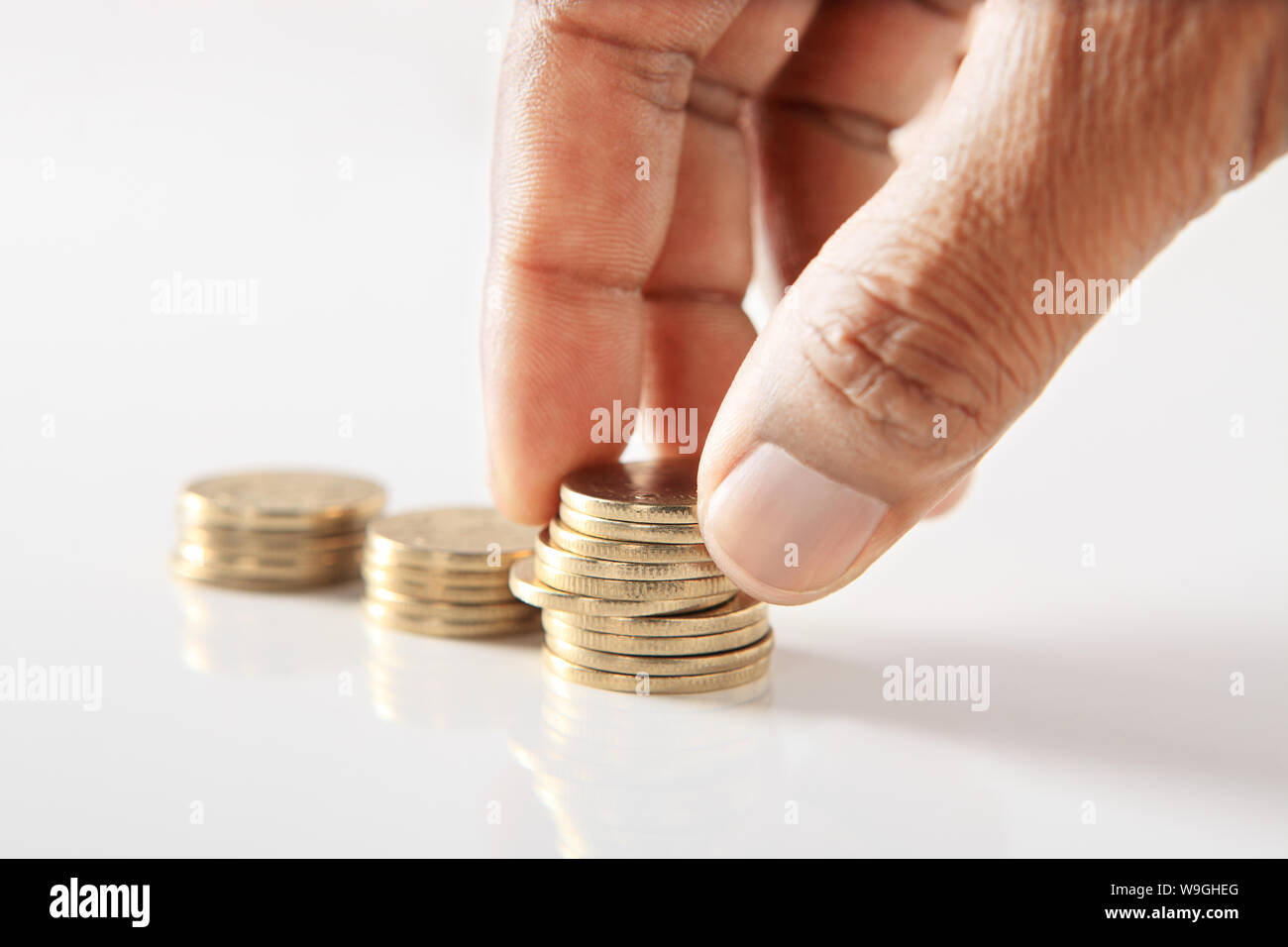 Persona mano che dispone le monete nella forma di grafico a barre Foto Stock