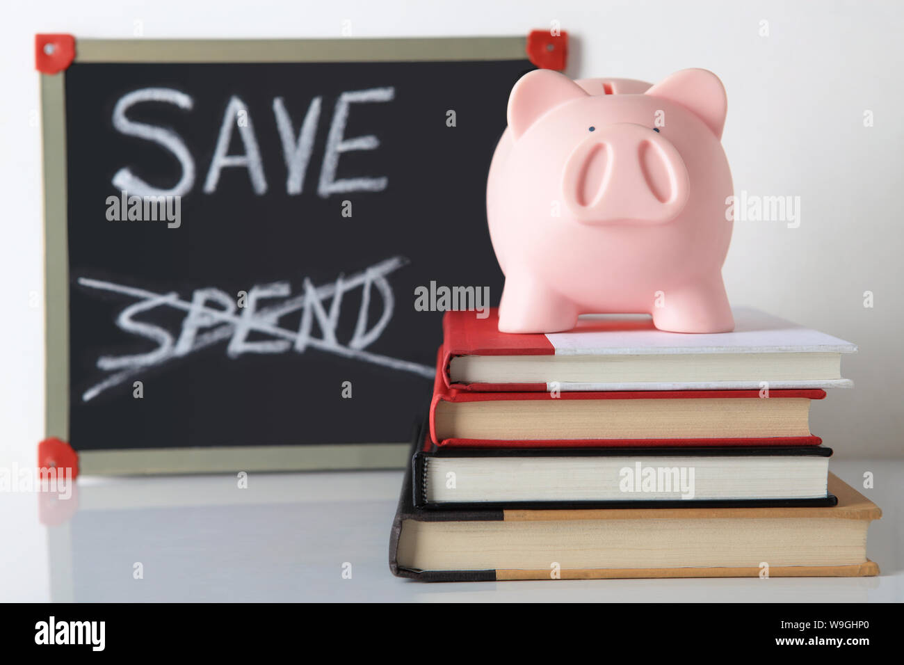 Salvadanaio sulla pila di libri Foto Stock