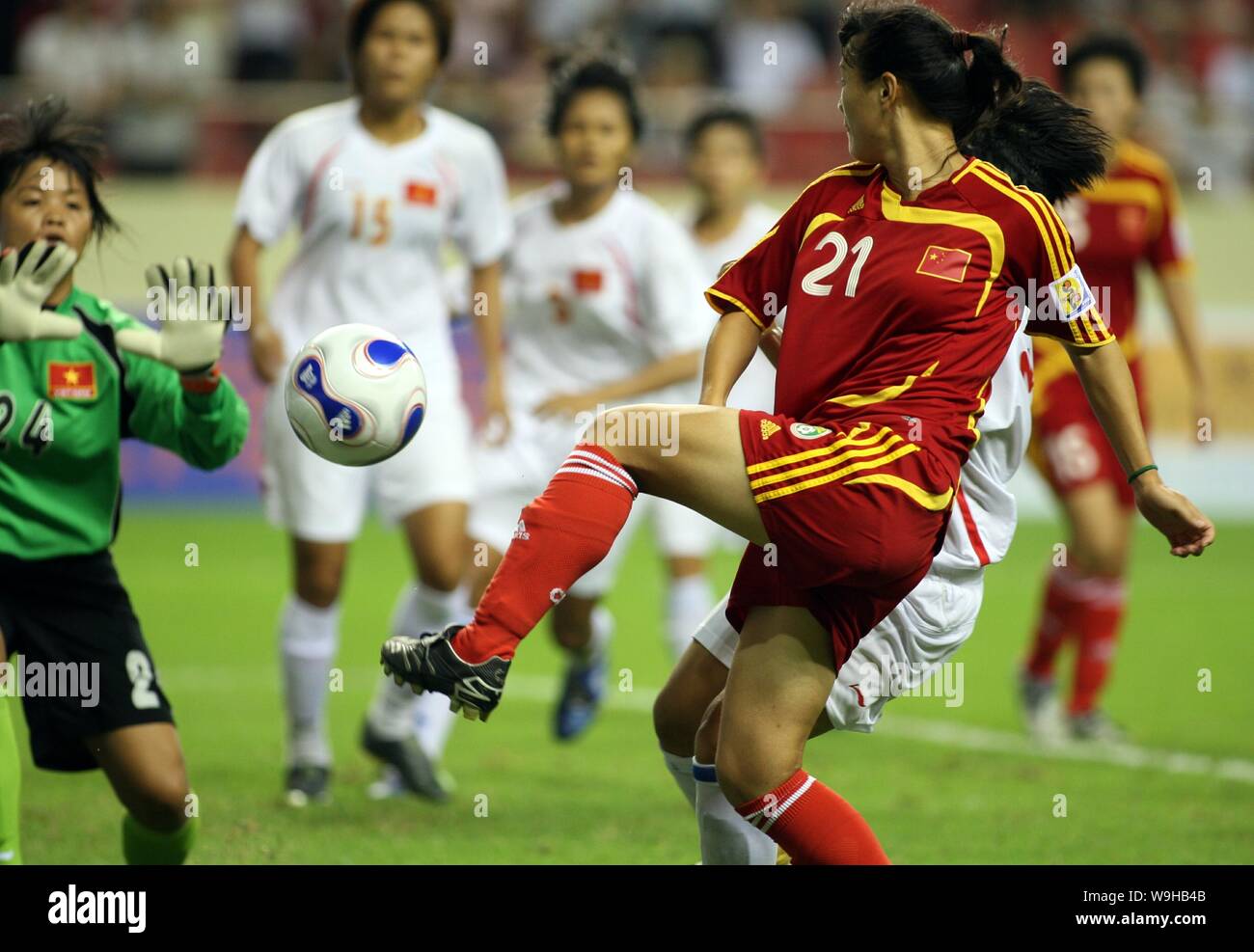 Un lettore cinese, destra, compete con i giocatori del Vietnam nel corso di un cordiale incontro di calcio tra la nazionale cinese donne squadra di calcio e il vietnamita n Foto Stock