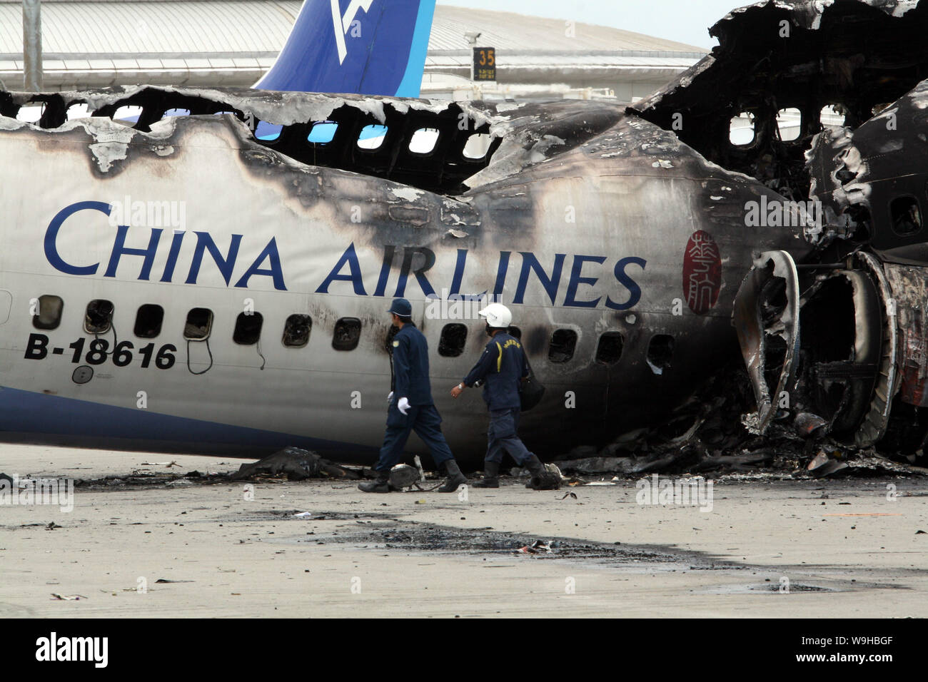 Gli esperti di aviazione giapponesi e di Taiwan di aviazione civile controllare i detriti di una China Airlines aereo all'aeroporto di Naha in Giappone, 21 agosto 2007. Un Boe Foto Stock