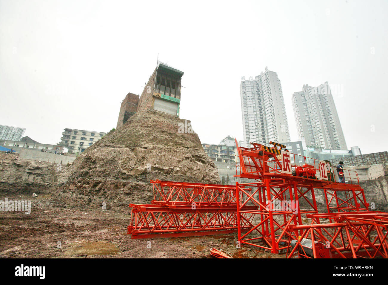 La casa isolata che si trova solo in un 30 piedi profondo uomo fatto buca ad un immobile sito in costruzione prima di essere demolito dal governo locale in Foto Stock