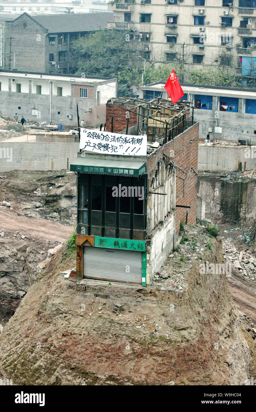 La casa isolata che si trova solo in un 30 piedi profondo uomo fatto buca ad un immobile sito in costruzione prima di essere demolito dal governo locale in Foto Stock