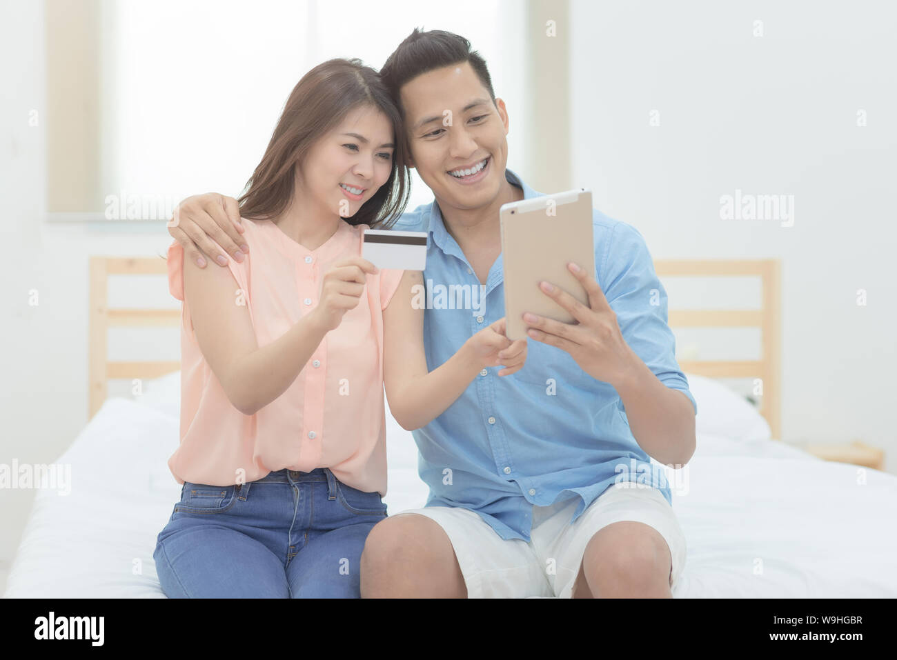 La famiglia felice,Asian giovane gli amanti della utilizzando smart tablet per lo shopping online insieme in camera da letto. Foto Stock