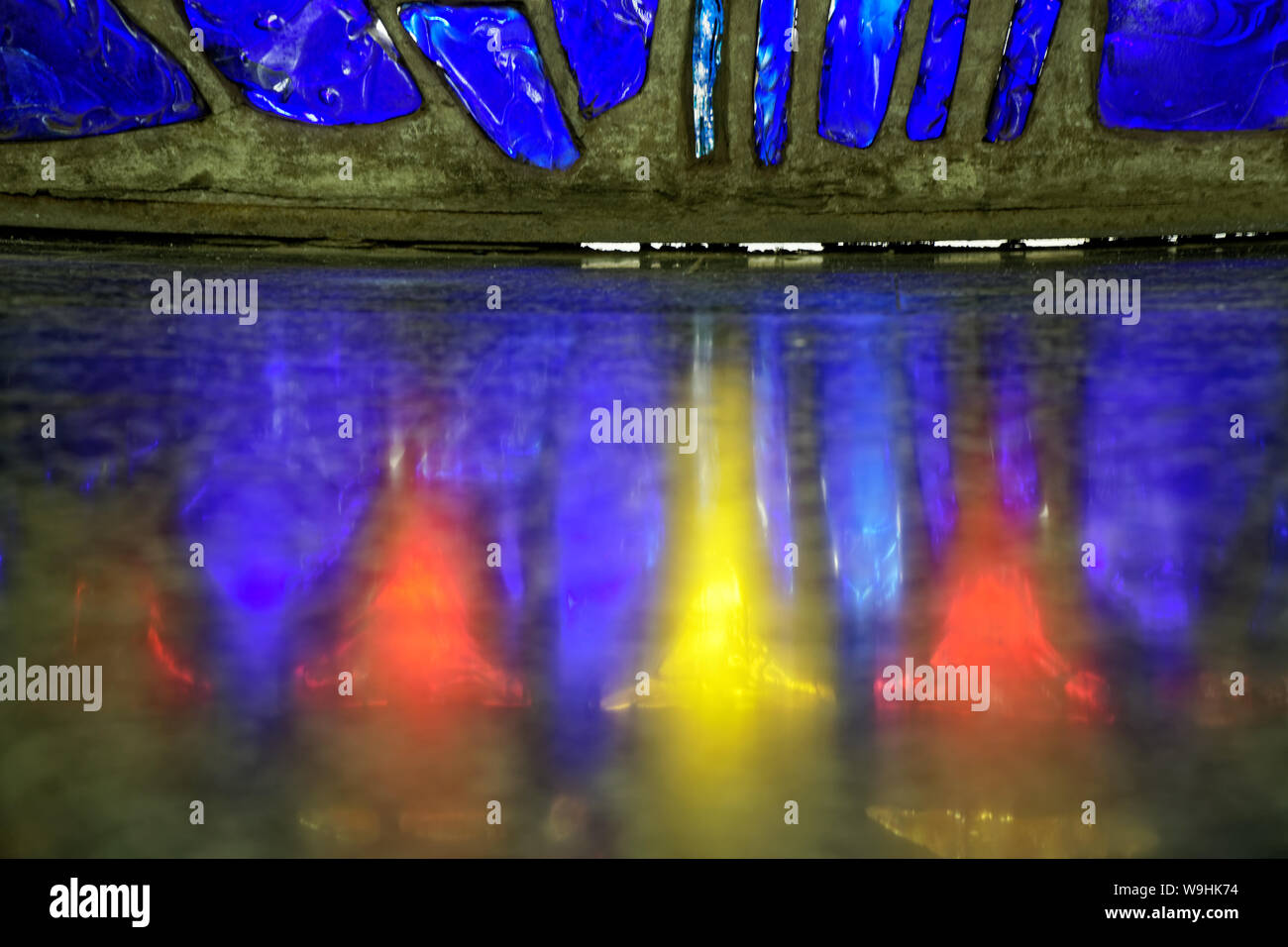 Mosaico di vetro da diversi pezzi con luci colorate. Foto Stock