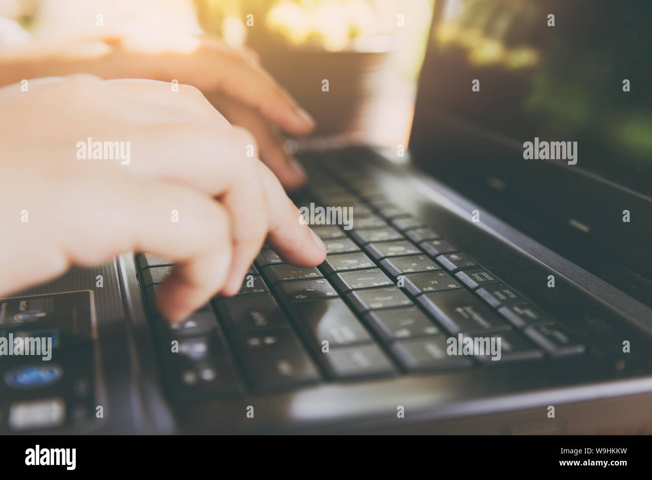 Vista dettagliata parte digitando su computer portatile per giorno lavorativo vintage tono colore Foto Stock
