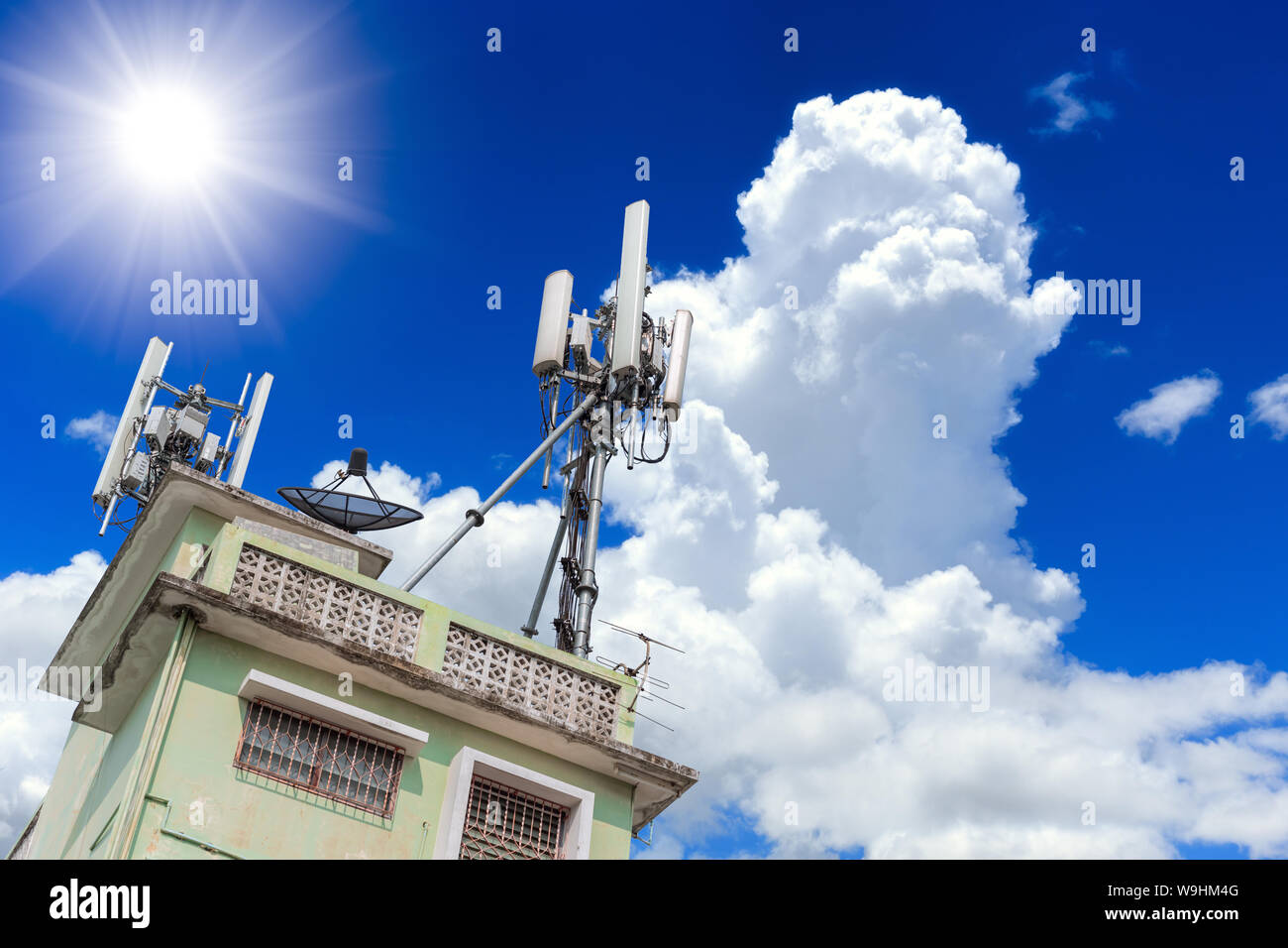 Comunicazione telefonica cella della torre principale del sito di alto edificio con cielo blu sullo sfondo Foto Stock