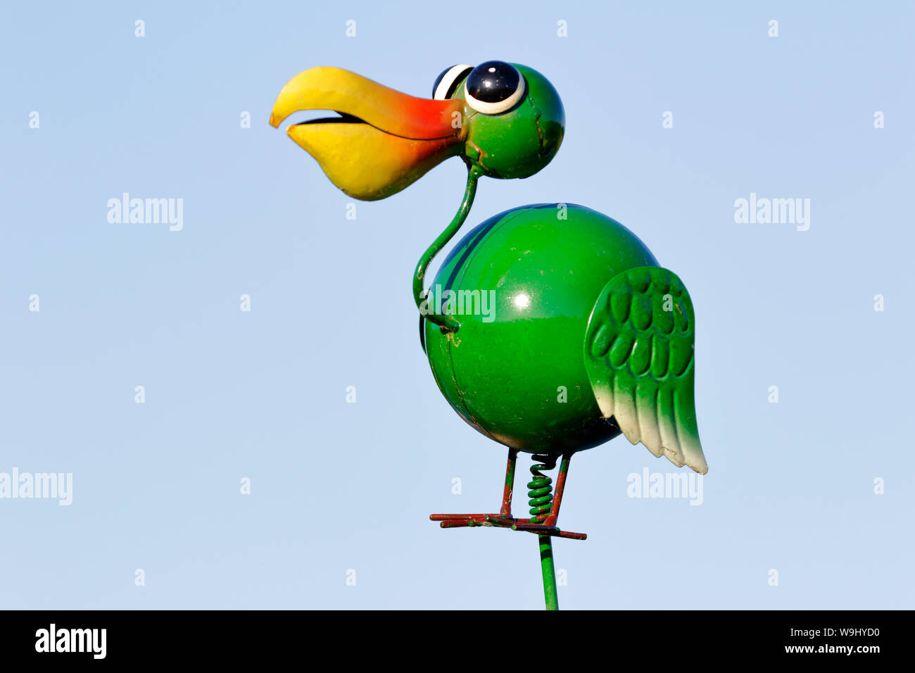 Pellicano verde ornamento o giocattolo su una molla contro una pianura cielo blu sullo sfondo Foto Stock