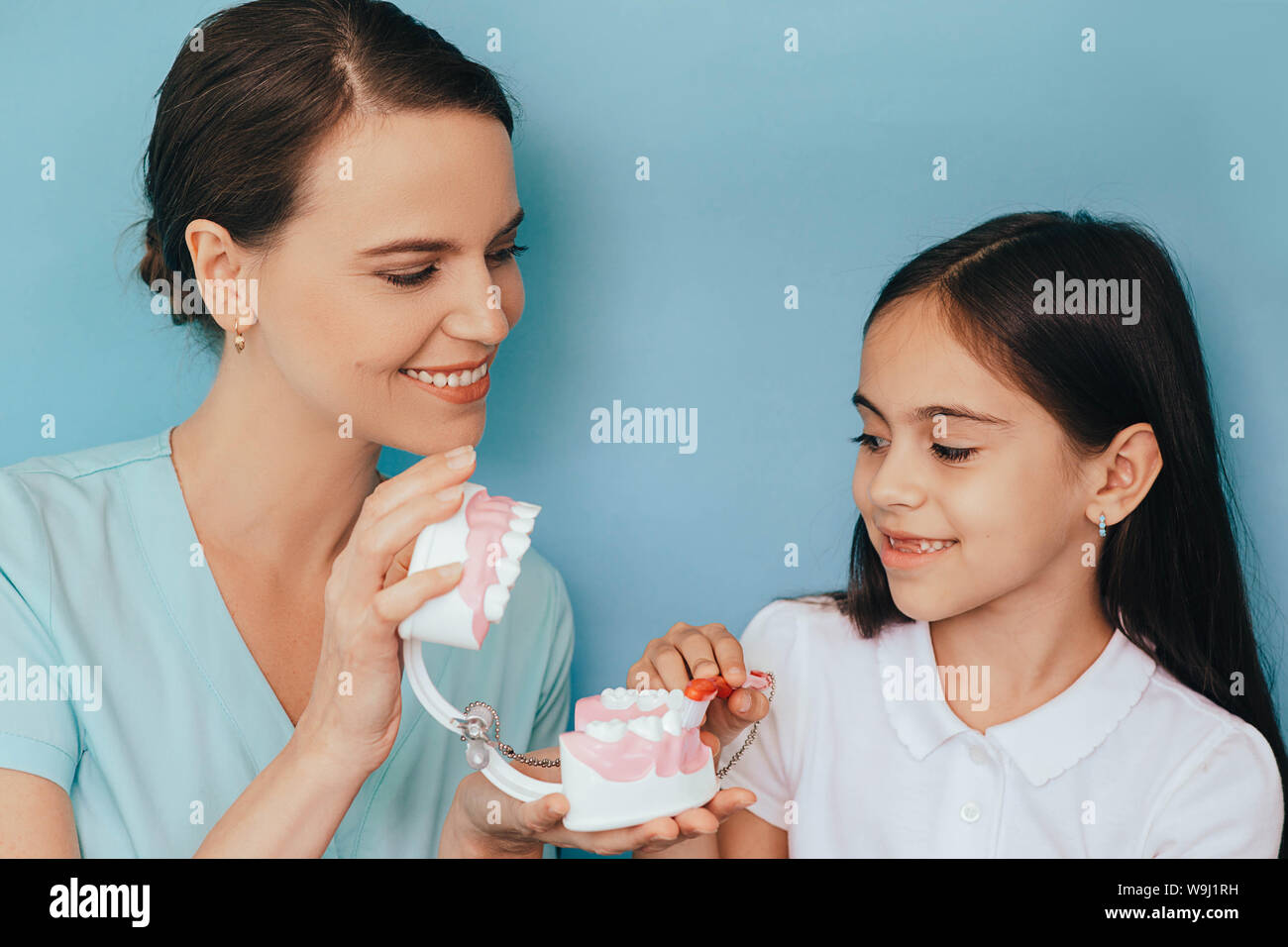 Razza mista ragazza che mostra come spazzola denti al suo dentista, durante un appuntamento dentale Foto Stock