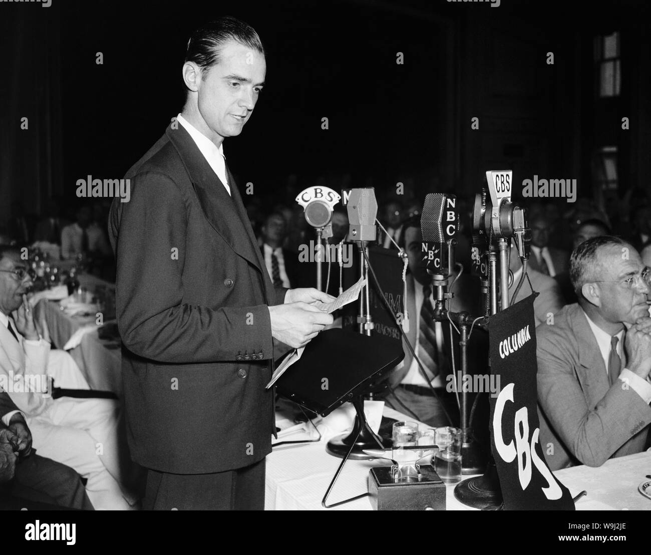 Foto d'epoca di American business tycoon, pilota, ingegnere, produttore di film e filantropo Howard Hughes (1905 - 1976). La foto è stata presa come Hughes ha parlato a un National Press Club pranzo in DC di Washington il 21 luglio 1938, pochi giorni dopo ha impostato un record di aviazione completando un giro del mondo in volo in poco più di 91 ore. Foto Stock