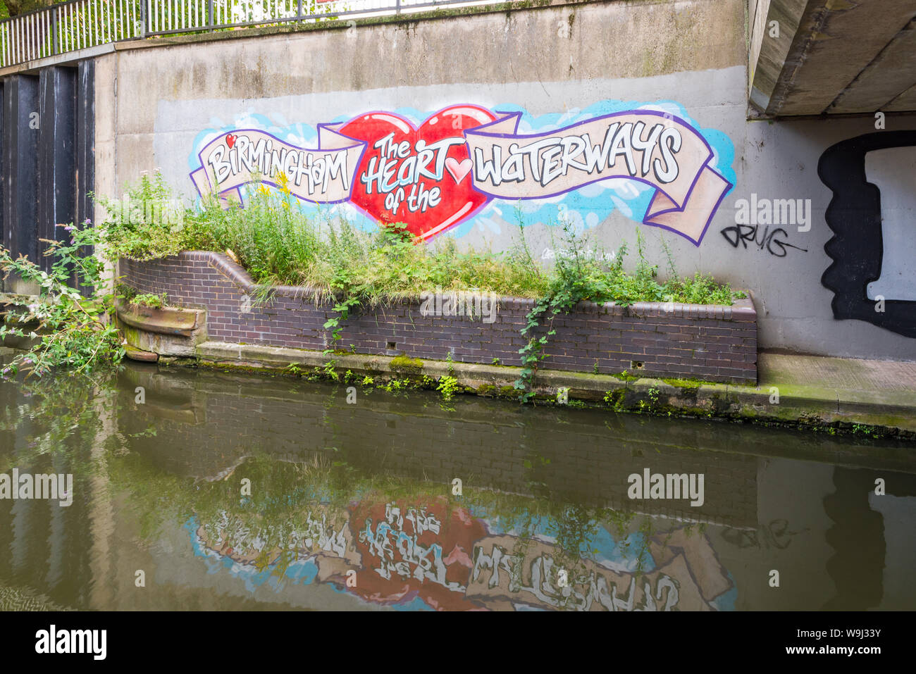 Cartello che diceva "Birmingham Cuore delle vie navigabili' dipinta su un muro a fianco di un canale nel centro di Birmingham, Regno Unito Foto Stock
