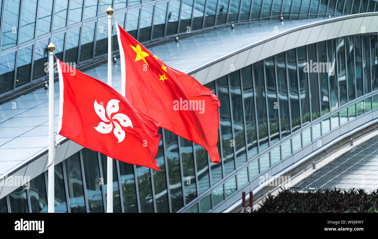 Hong Kong e la Cina continentale bandiere nazionali di stare in piedi insieme con copia spazio. Il simbolo della nazione, paesi conflitto politico concetto Foto Stock