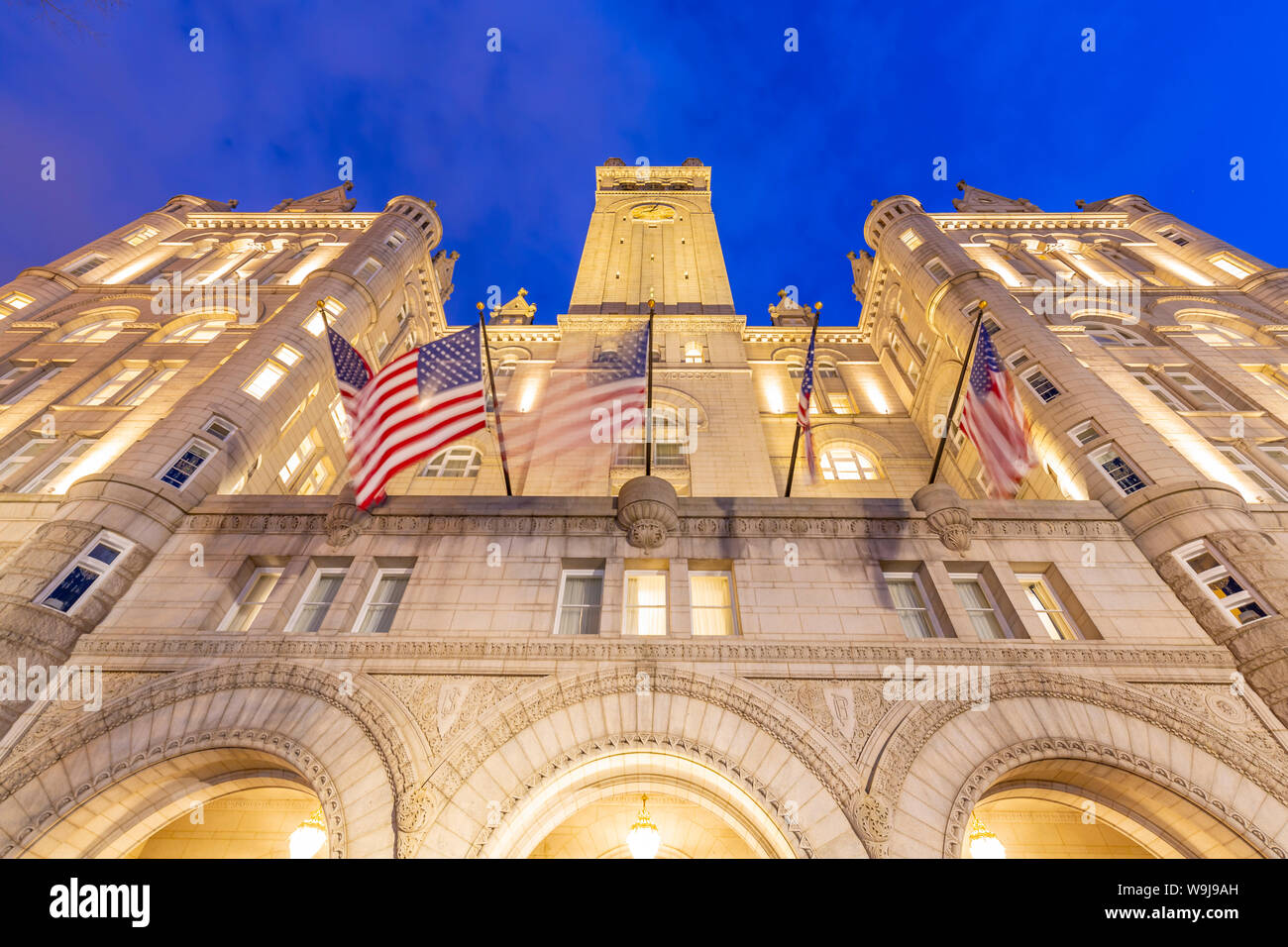 Vista delle bandiere degli Stati Uniti di fronte all'ex Old Post Office Pavilion al crepuscolo, Washington DC, District of Columbia, Stati Uniti d'America Foto Stock