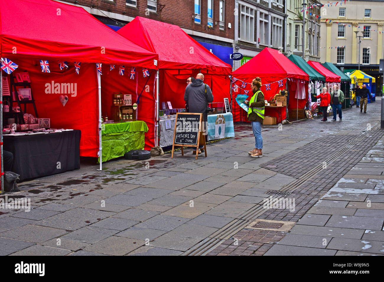 'Tempo di guerra Bridgend'. Evento annuale ricreando luoghi e suoni della seconda guerra mondiale. Persone che camminano da colorate bancarelle del mercato in Caroline Street. Foto Stock