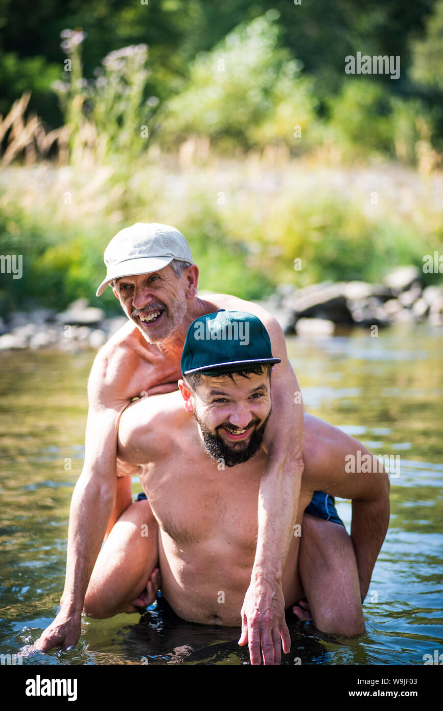 Padre e figlio divertirsi in acqua di un fiume in una calda giornata estiva Foto Stock