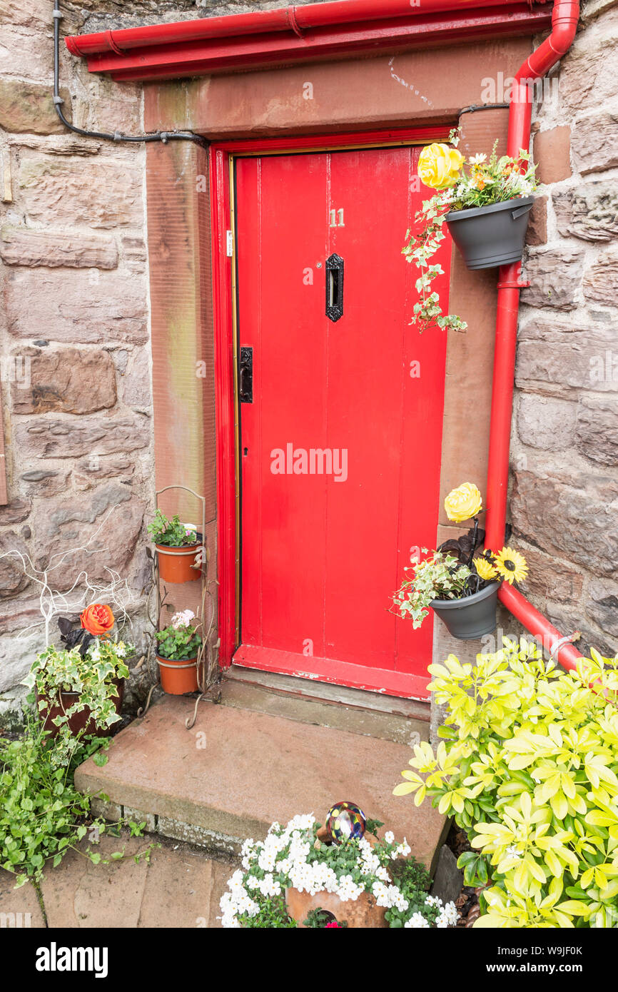 Appleby-in-Westmoreland, Cumbria, Inghilterra. Dettaglio di un rosso porta nel cortile in ciottoli della St Anne's Hospital e la cappella. Foto Stock