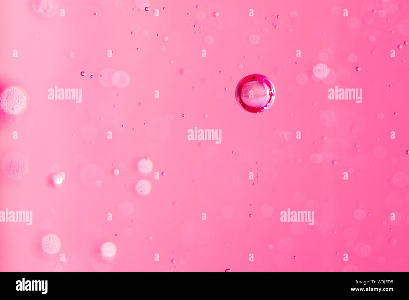 Macro delle bolle di ossigeno in acqua su un sfondo rosa, concetti come ecologia e altri elevando i progetti di successo Foto Stock