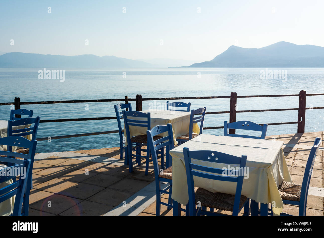 Tabelle vuote di fronte al mare in Grecia Foto Stock