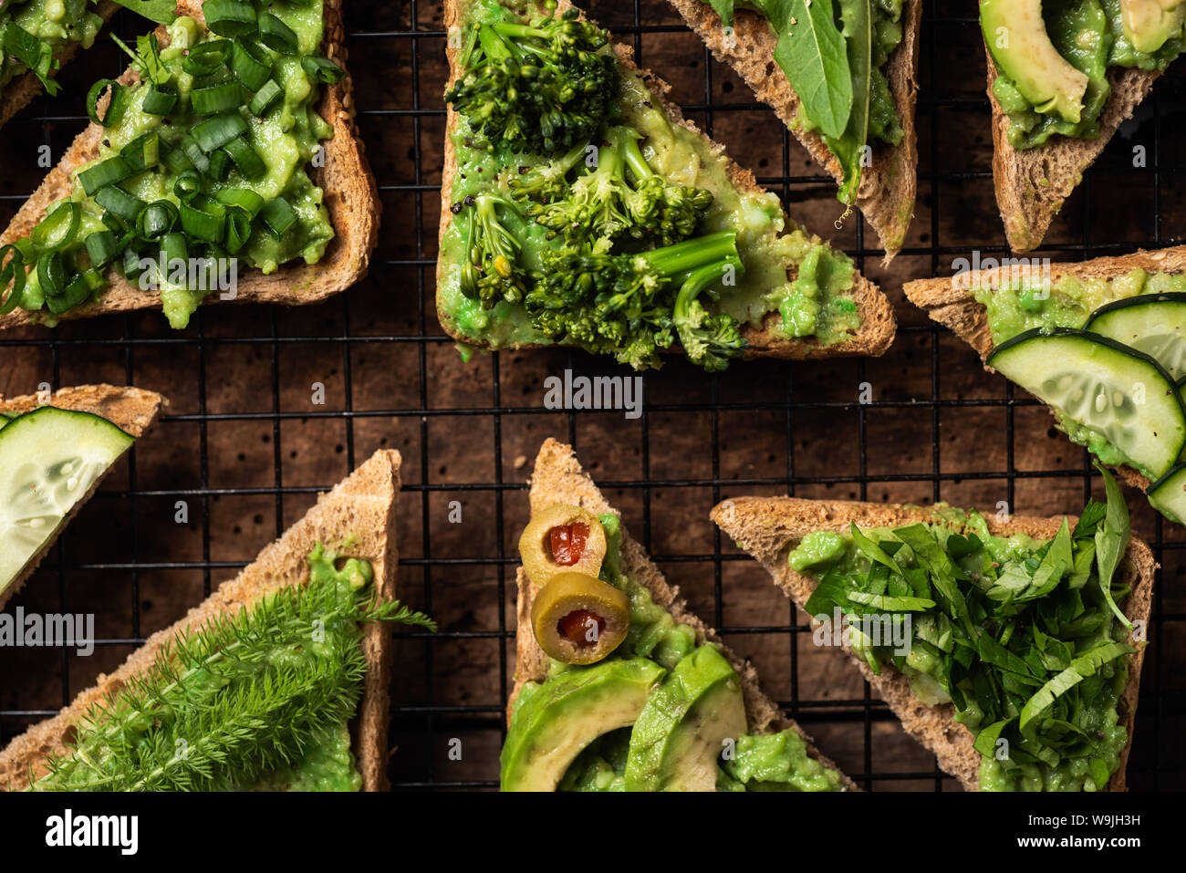 Sandwich vegetariano con il guacamole e le verdure su una superficie di legno Foto Stock