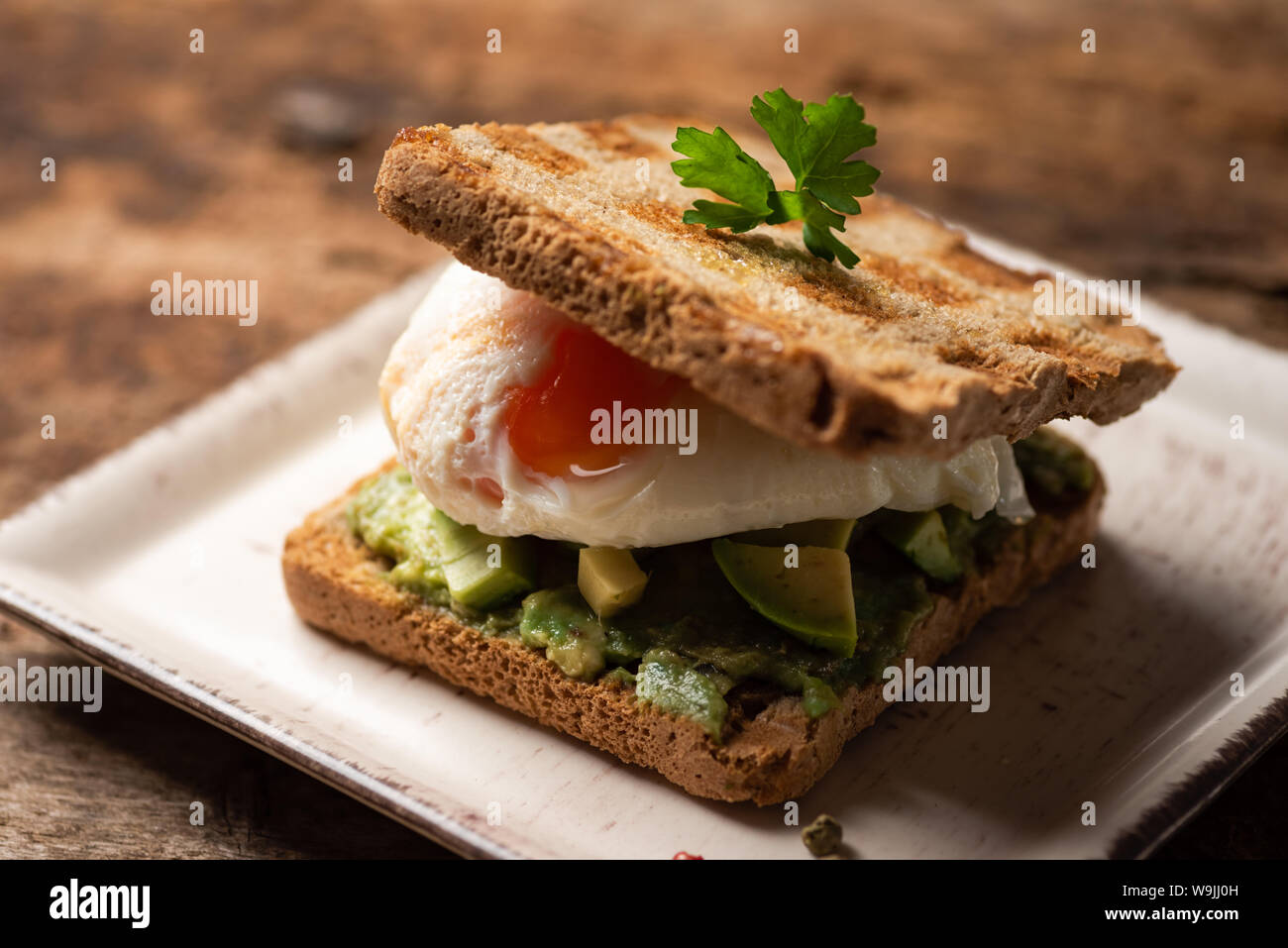 Freschi sandwich toast con uova fritte e avocado Foto Stock