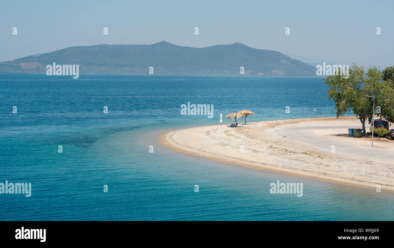 Spiaggia vuota su un isola greca con una aletta parasole Foto Stock