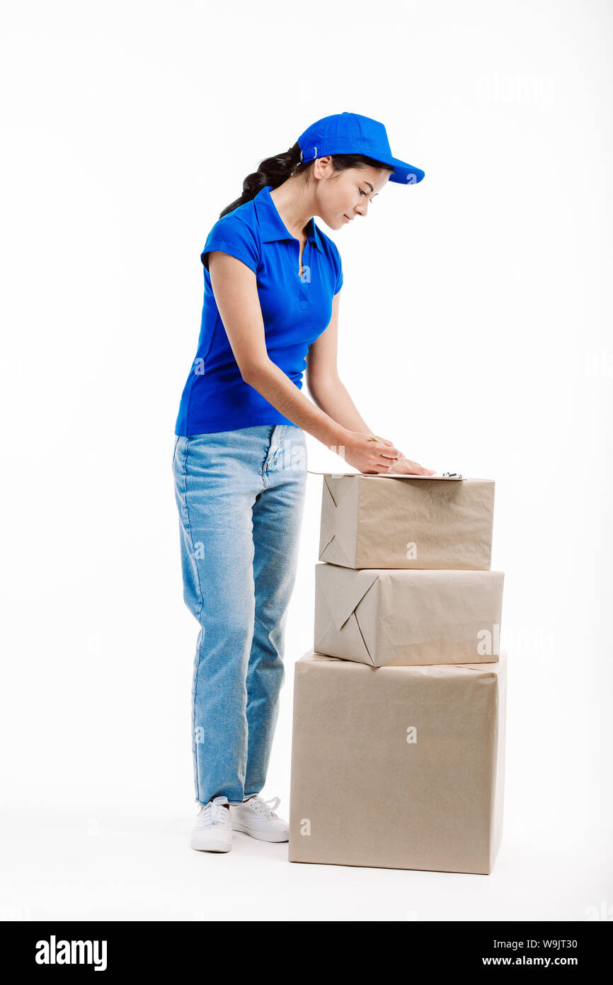 Post office lavoratore navi pacchi imballati con attenzione i clienti elencati nella compressa che lei utilizza. Foto Stock